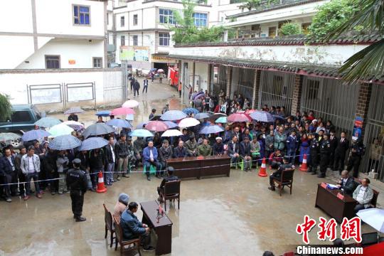 虽然下着大雨，法院的以案释法仍受到村民欢迎。　乐华方 摄