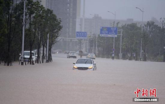 7月1日，长沙含浦大道上一辆小车被洪水围困。当日，暴雨致长沙城区多处内涝。杨华峰 摄