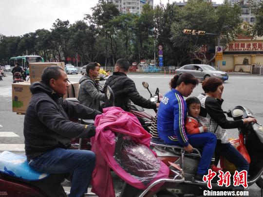 12日，雨后的昆明街头微凉，行人各种棉衣、外套紧裹。　胡远航 摄